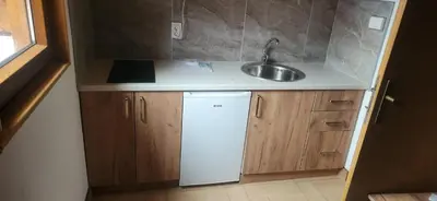 a small kitchen with a sink and a refrigerator at Bungalovi Potočarska panorama in Mrkonjić Grad