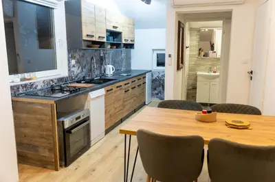 a kitchen with a wooden table and a dining room at Guest House Lejla 2 in Travnik