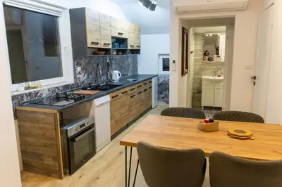 a kitchen with a wooden table and a dining room at Guest House Lejla 2 in Travnik