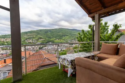 a balcony with a table and chairs and a view at Guest House Lejla 2 in Travnik