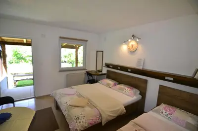 a bedroom with two beds and a clock on the wall at Domaćinstvo Una-Ostrovica in Kulen Vakuf