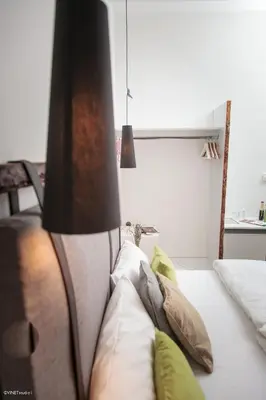 a lamp sitting next to a bed with pillows at HOTEL Pyramid Lodge in Visoko