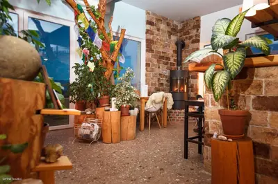 a room with potted plants and a table and chairs at HOTEL Pyramid Lodge in Visoko