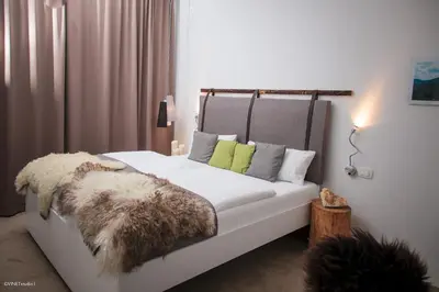 a bedroom with a white bed with a fur blanket at HOTEL Pyramid Lodge in Visoko
