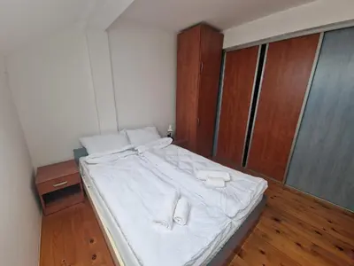 a bed with white sheets and white towels on it at Apartman Sofija 2 in Banja Luka