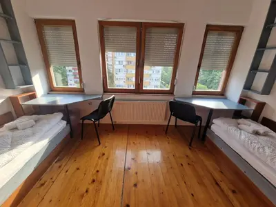 a room with two beds and two tables and windows at Apartman Sofija 2 in Banja Luka