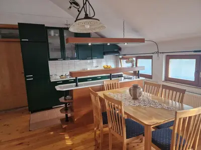 a kitchen with a wooden table and a dining room at Apartman Sofija 2 in Banja Luka