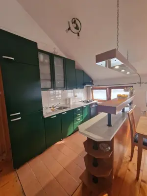 a kitchen with green cabinets and a table at Apartman Sofija 2 in Banja Luka