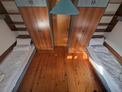 a small room with two beds and wooden cabinets at Apartman Sofija 2 in Banja Luka