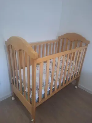 a wooden crib in a corner of a room at Apartman L&S in Doboj
