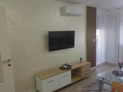 a living room with a flat screen tv on the wall at Apartman L&S in Doboj