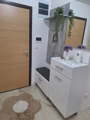 a white kitchen with a door and a rug at Apartman L&S in Doboj