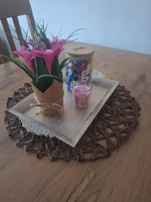 a table with a plate with a plant and a candle at Apartman L&S in Doboj