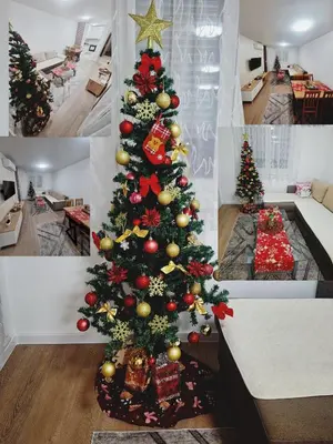 a christmas tree in a living room with presents at Apartman L&S in Doboj