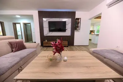 a living room with a table with flowers on it at Holiday Residence Šehić in Visoko