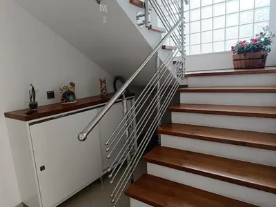a staircase with wooden treads and a white stair case at Villa Sienna in Smrdan