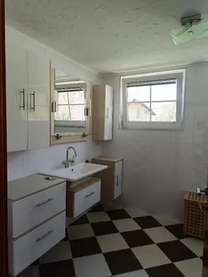 a bathroom with a sink and a checkered floor at Villa Sienna in Smrdan