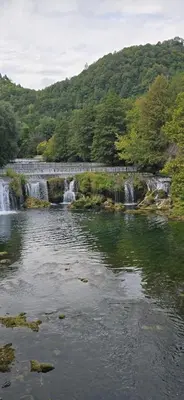a bridge over a river with a waterfall at Villa Sienna in Smrdan