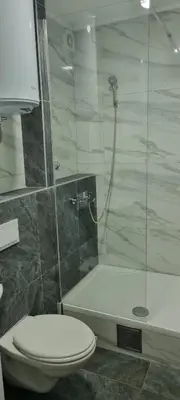 a bathroom with a toilet and a glass shower at Apartmani EŠ in Ivišovo Greblje