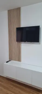 a flat screen tv on top of a white entertainment center at Apartmani EŠ in Ivišovo Greblje