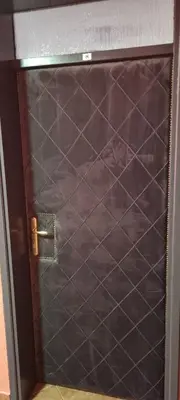 a metal door with a brown tiled wall at Apartmani EŠ in Ivišovo Greblje