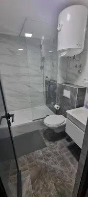 a bathroom with a shower and a toilet and a sink at Apartmani EŠ in Ivišovo Greblje