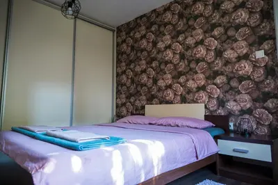 a bedroom with a bed with a floral wall at Gajic & Milini in Banja Luka