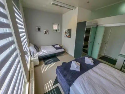 a room with two beds and a balcony with a window at Oasis in Bihać
