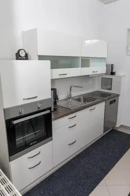a white kitchen with a sink and a stove at Oasis in Bihać