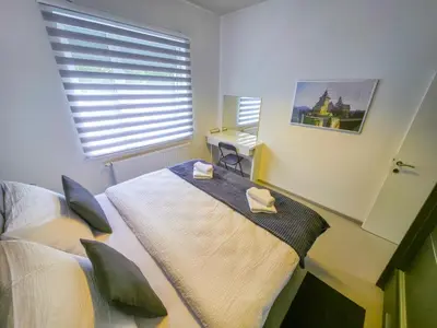 a bedroom with a bed and a desk and a window at Oasis in Bihać