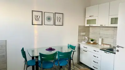 a kitchen with a glass table and blue chairs at Apartman Dina in Sanski most