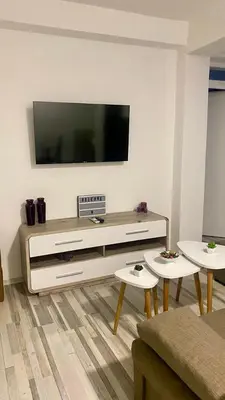 a living room with a flat screen tv on a wall at Apartman Dina in Sanski most