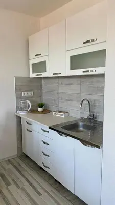 a kitchen with white cabinets and a sink at Apartman Dina in Sanski most