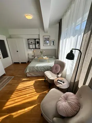 a bedroom with a bed and two chairs and a table at Studio Mint&White Borik in Banja Luka