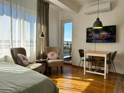 a bedroom with a bed and a table and chairs at Studio Mint&White Borik in Banja Luka