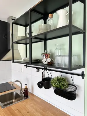 a kitchen with black shelves on the wall at Studio Mint&White Borik in Banja Luka