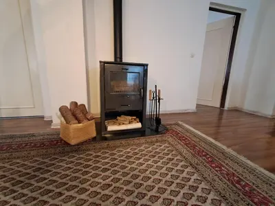 a living room with a fireplace and a rug at Boema in Ivišovo Greblje
