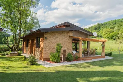 a house in a field with a grass yard at Mali Wimbledon in Visoko