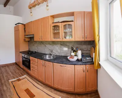 a kitchen with wooden cabinets and a sink at Mali Wimbledon in Visoko