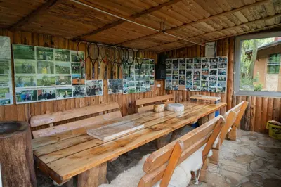 a dining room with a wooden table and benches at Mali Wimbledon in Visoko