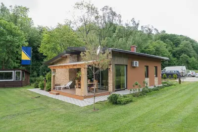 a small house in a yard with a grass field at Mali Wimbledon in Visoko