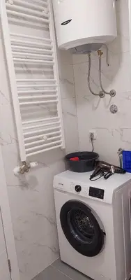 a white washing machine in a room with a window at Osmica Doboj in Doboj