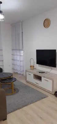 a living room with a flat screen tv on a white wall at Osmica Doboj in Doboj