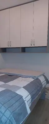 a bed in a room with white cabinets at Osmica Doboj in Doboj