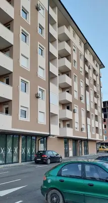 a green car parked in front of a building at Osmica Doboj in Doboj