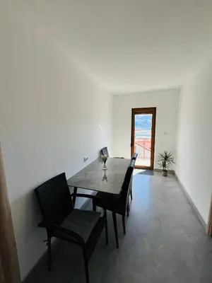 a dining room with a wooden table and chairs at Apartman Lucija in Rumboci