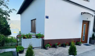 a house with potted plants on the side of it at Apartman Lucija in Rumboci
