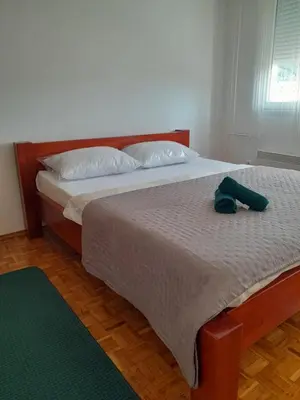 a bedroom with a bed with a hat on it at Apartman Borik Banja Luka in Banja Luka