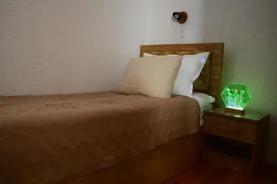 a bedroom with a bed with a lamp on a night stand at Apartman Nur in Bihać