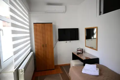 a small room with a bed and a television in it at Apartman Nur in Bihać
